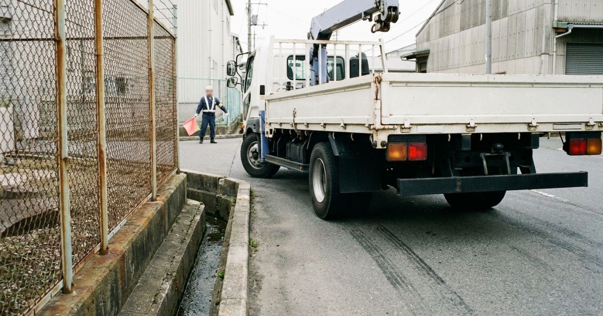 曲がり角でユニック車の内輪差と幅余裕を確認する場面