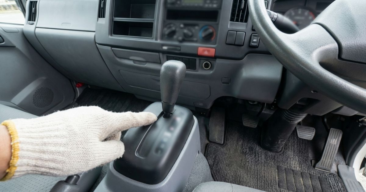 2トントラックの運転席まわりでATかMTかを確認しているシーン（表示文字なし）