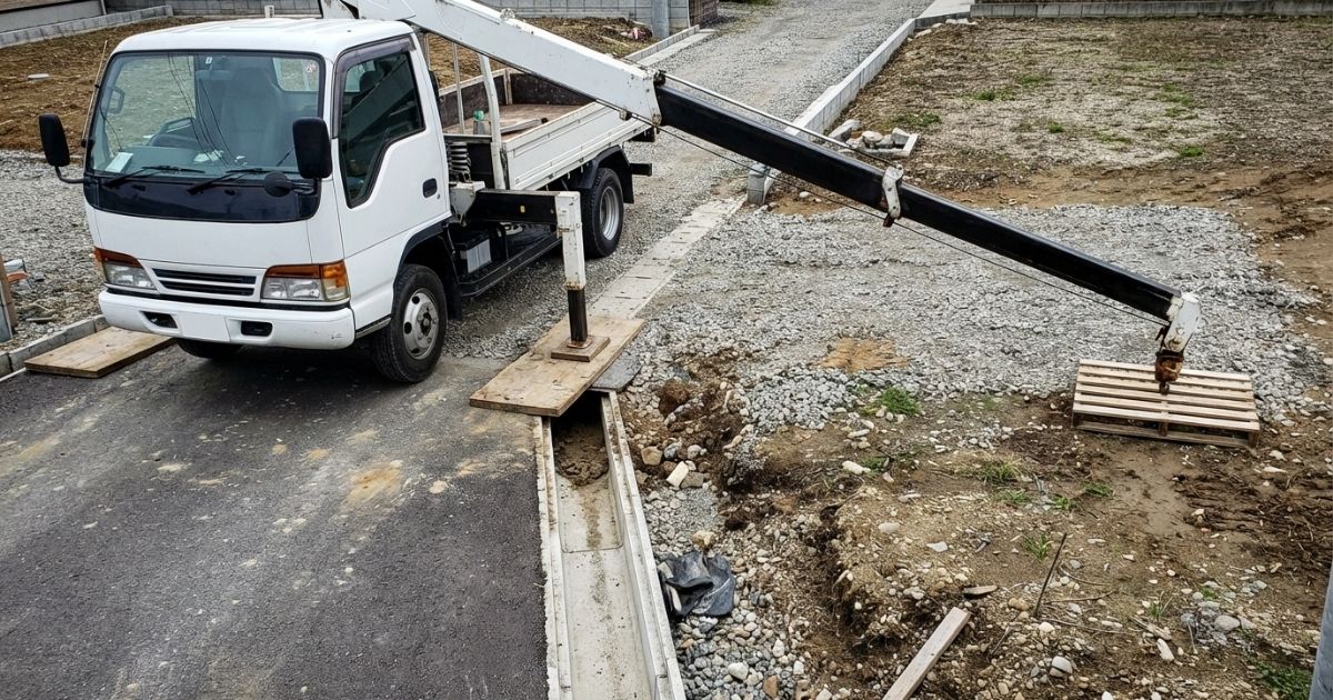 狭小現場でアウトリガー設置と作業半径の制約がある2tユニックの作業風景写真