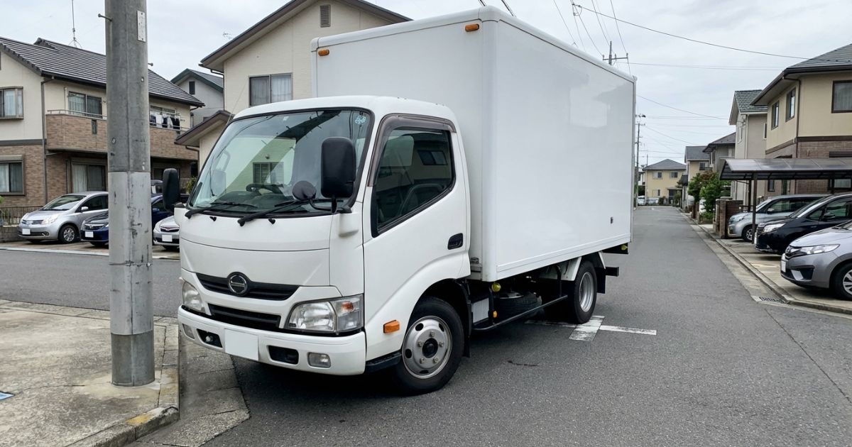 3トントラックが市街地の交差点を低速で曲がる様子を表したイメージ写真