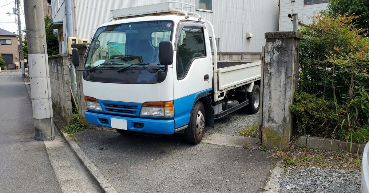 狭い現場入口で旋回を判断する4tトラックの写真