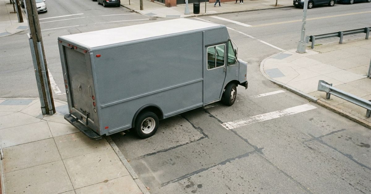 4tトラックが交差点で左折する場面を写した写真風イメージ