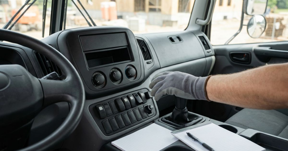 いすゞユニック車の運転席周りでPTO操作を確認しているイメージ