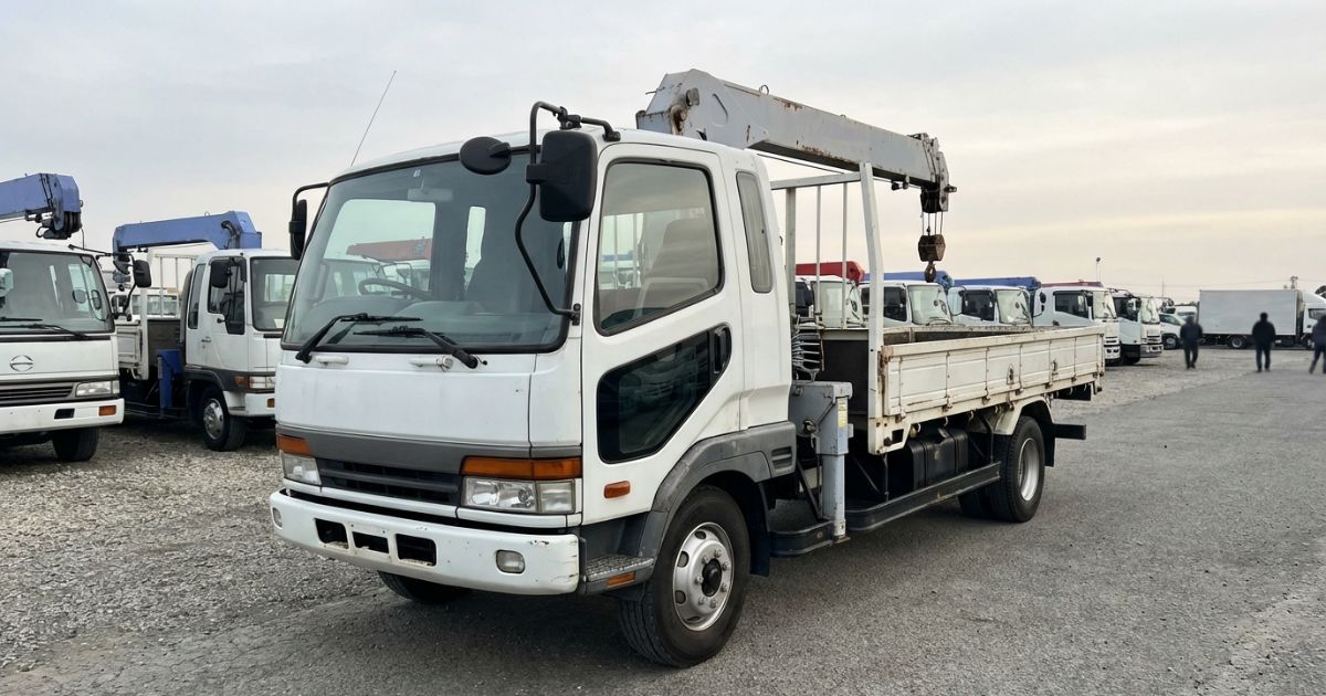 中古のクレーン付きトラックを販売ヤードで比較検討しているイメージ写真