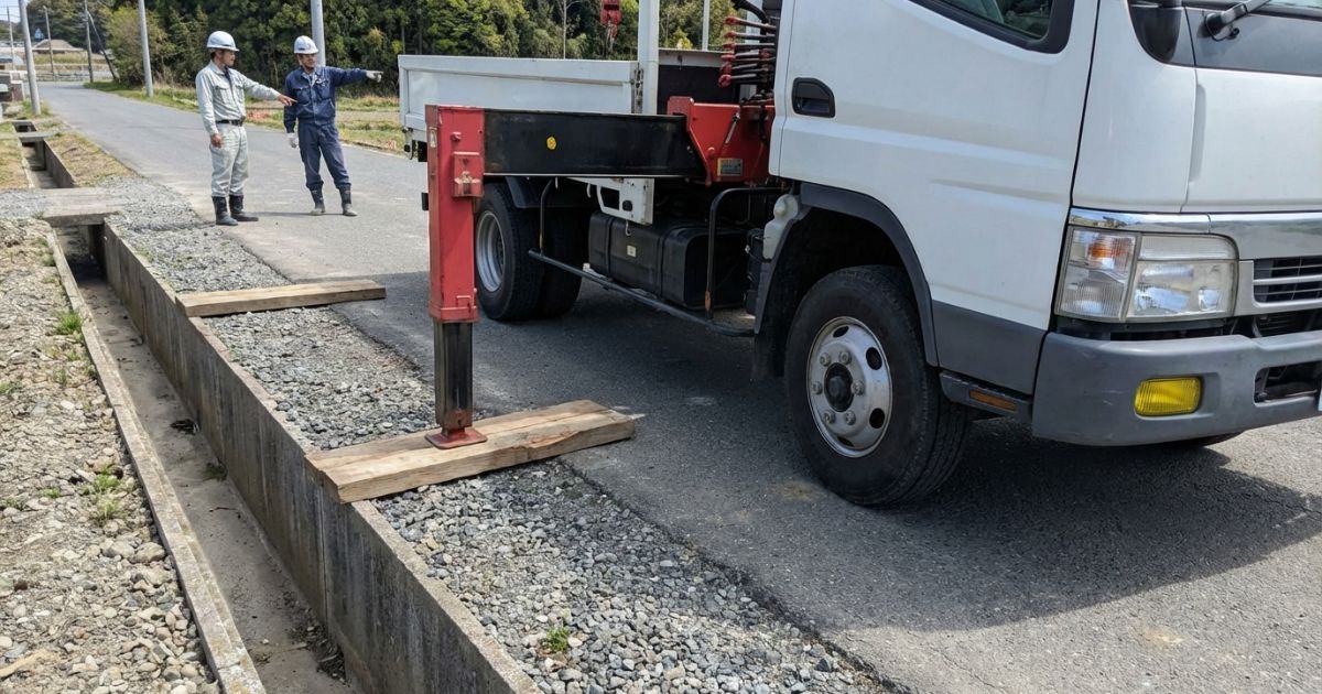 路肩や側溝付近で敷板の置き場と左右バランスに不安があり続行せず修正や中止判断を検討している例