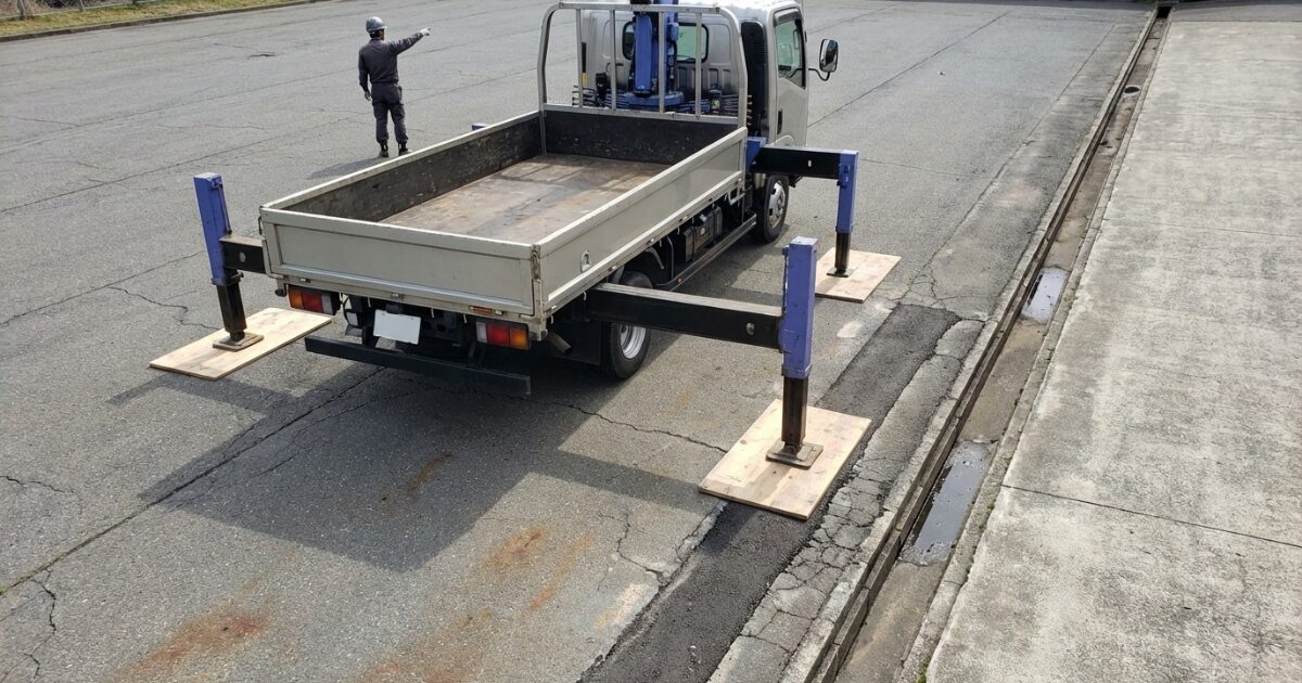 舗装端部や目地付近でも敷板で荷重分散し安全にアウトリガーを設置している例