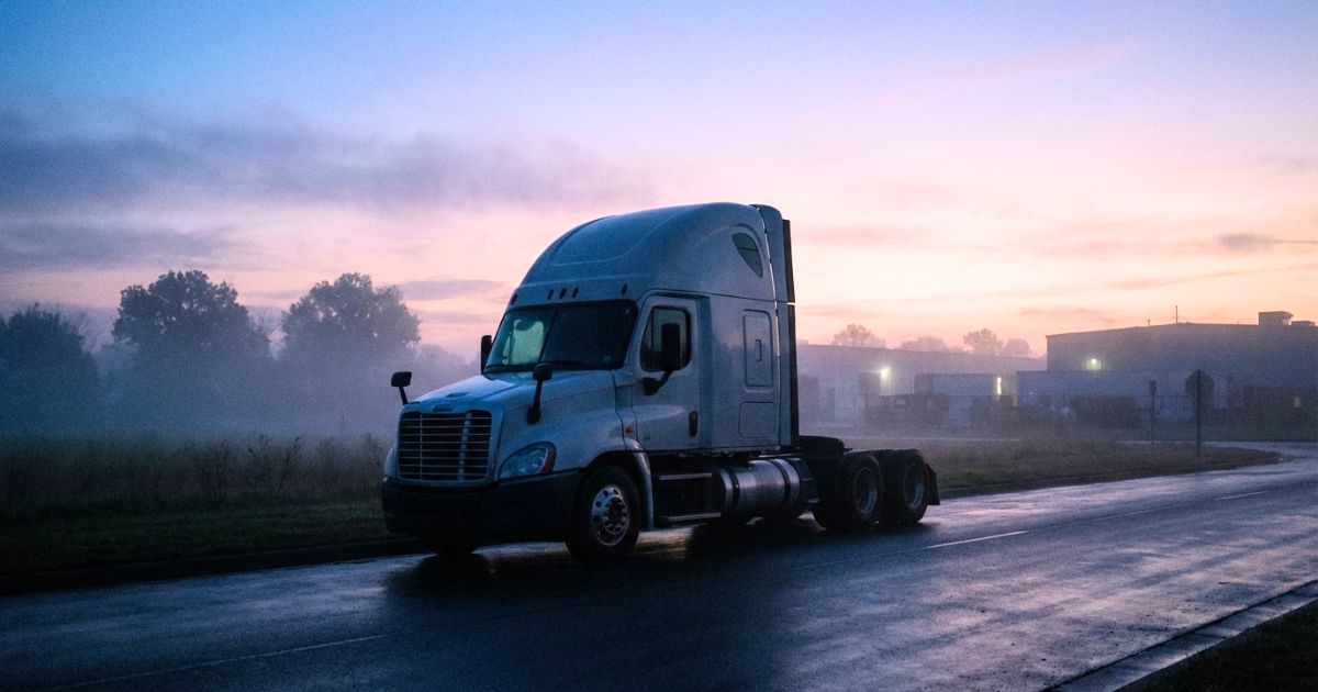薄明の道路に佇む大型トラックの夢の雰囲気写真風イメージ